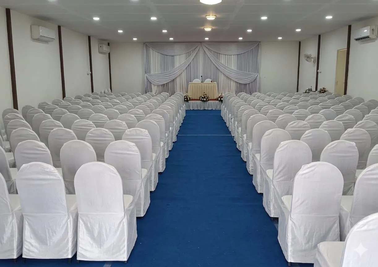 Banquet hall with white chairs and blue aisle